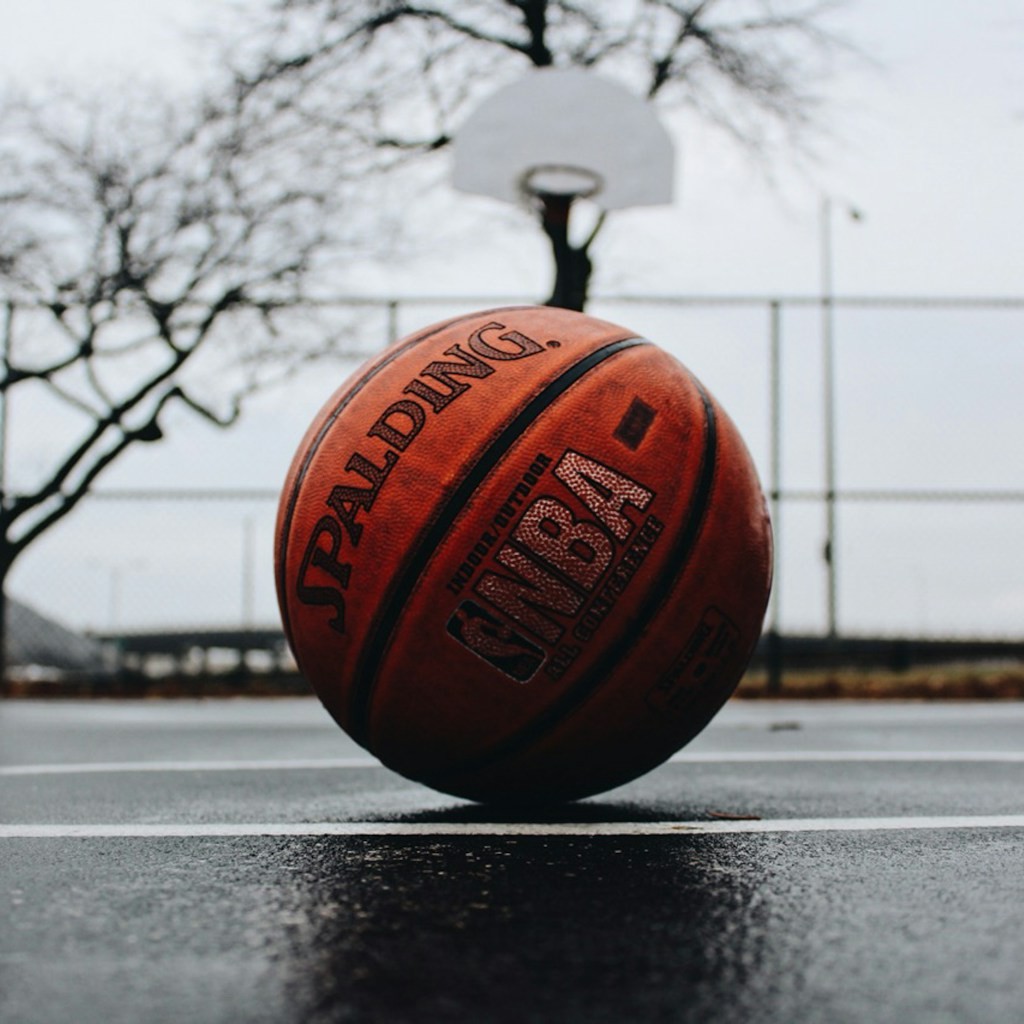 A basketball rim and net seen from below in an empty gym